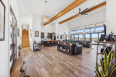 Living room featuring beam ceiling, a towering ce