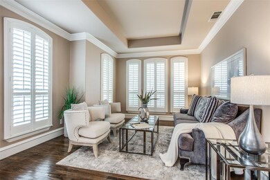 Living room with a wealth of natural light, hardwood / wood-style floors, and a tray ceiling