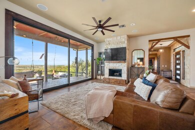 Living area featuring ceiling fan, a stone firepl