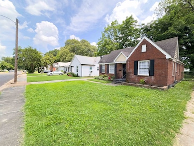 View of front of property featuring brick siding, a front yard, and roof with shingles