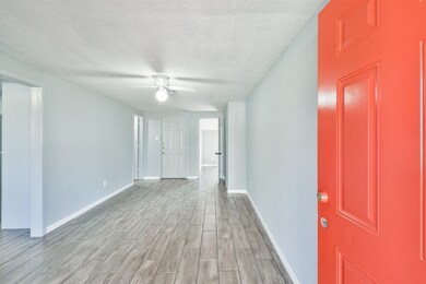 The entrance leads to the living room area. To the far right is a bedroom, the middle door leads to the exterior, and the left door is the 2nd bathroom. The entryway to the left leads to the kitchen, dining, and other 2 bedrooms.