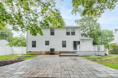 Rear view of home, stone patio, and two-tiered com