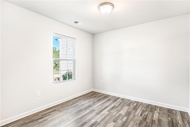 Spare room featuring wood finished floors and baseboards