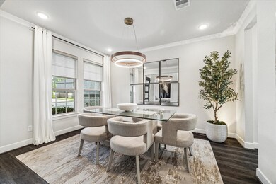 This modern dining room featuring a contemporary lighting, large windows with vinyl plank wood flooring and a neutral color palette.