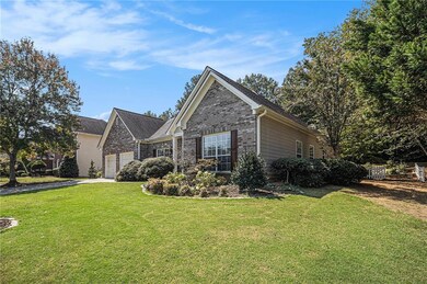 View of front of home featuring a front lawn, brick siding, an attached garage, and driveway
