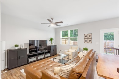 Living area with ceiling fan and light wood-type flooring