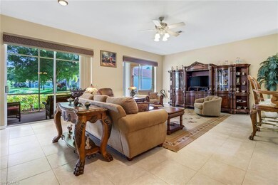 Living room with ceiling fan and light tile patter