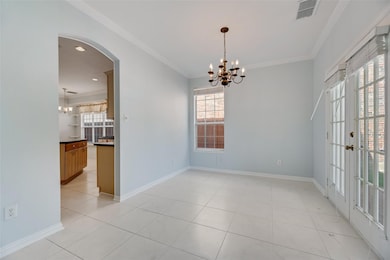 Unfurnished room with a chandelier, arched walkways, crown molding, and light tile patterned floors