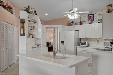 Kitchen with vaulted ceiling, white appliances, wh