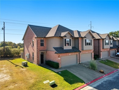 View of front of property featuring driveway, brick siding, a front yard, roof with shingles, and a garage