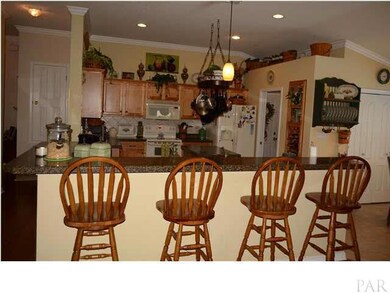 Beautiful kitchen with plant ledges, large breakfast bar, and recessed lighting.
