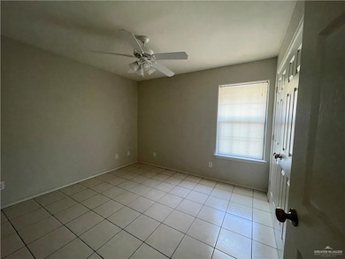 Spare room with ceiling fan and light tile patterned floors