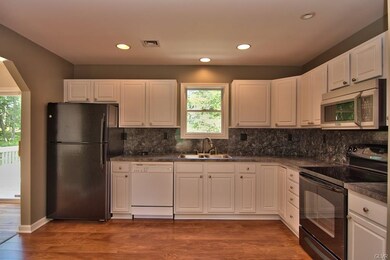 The kitchen features laminate floors, recessed lig