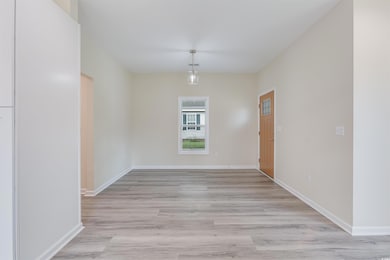 Unfurnished dining area with light wood-style flooring and baseboards