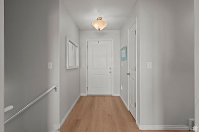 Hallway featuring light wood-style flooring and an upstairs landing