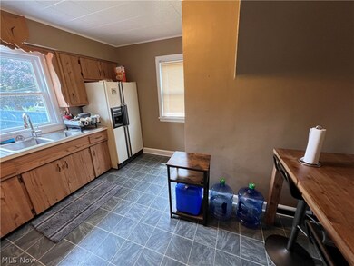 Kitchen featuring sink, dark tile flooring, and white fridge with ice dispenser