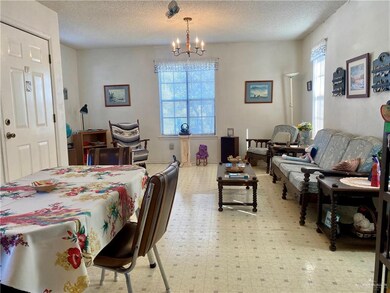 Dining space with a notable chandelier, a healthy amount of sunlight, and light tile floors