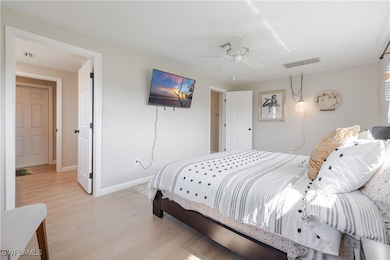 Bedroom with ceiling fan and light hardwood / wood