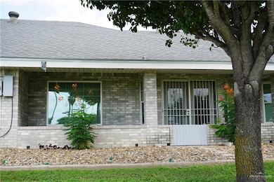 View of home's exterior featuring roof with shingles and brick siding