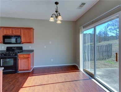 Kitchen with black appliances, an inviting chandel
