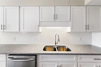 Kitchen with sink, white cabinets, dishwasher, and