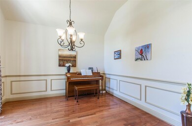 Dining area with lofted ceiling, an inviting chandelier, and hardwood  flooring