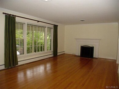 Living room with oak floor and wood-burning firepl