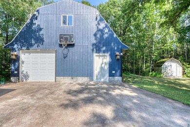 Garage featuring driveway, a storage unit, and a garage