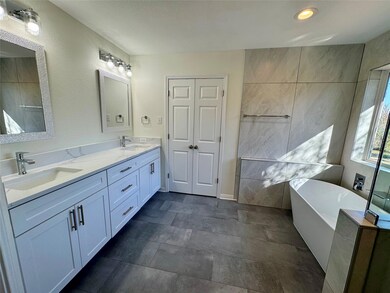 Bathroom featuring a soaking tub, double vanity, 