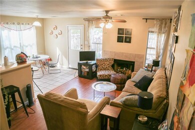 Living room featuring ceiling fan, a fireplace, a