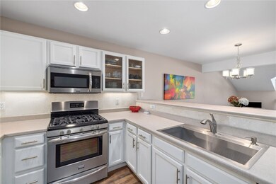 Kitchen featuring white cabinetry, sink, and appli