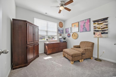 Sitting room with ceiling fan, light colored carpet, and baseboards