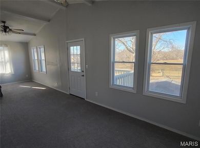 Foyer with vaulted ceiling with beams, carpet, a ceiling fan, and baseboards