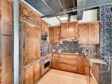 Kitchen featuring built in appliances, backsplash