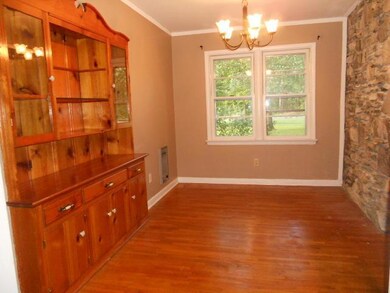 Formal Dining Room with built in, hardwood floors and stone wall