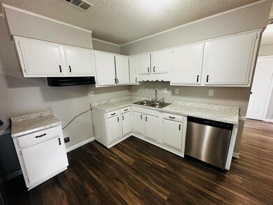 Kitchen with visible vents, white cabinetry, a sin