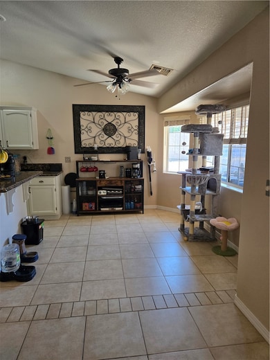 Dining space featuring ceiling fan, a textured cei