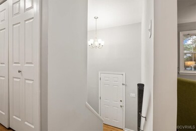 Hall featuring a notable chandelier and hardwood /