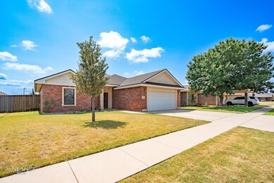 Single story home with a garage and a front yard