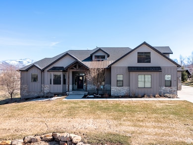 Modern inspired farmhouse with a standing seam roof, a front lawn, stone siding, board and batten siding, and roof with shingles