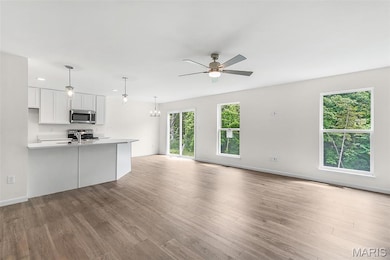 Unfurnished living room with a chandelier, light wood finished floors, and ceiling fan