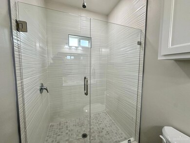 Bathroom with a shower with shower door and toilet