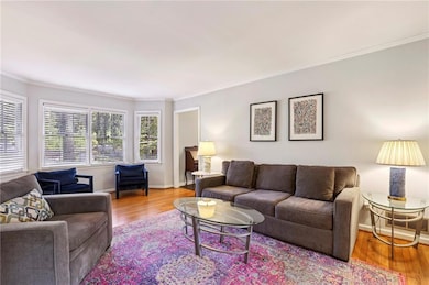 Living room featuring ornamental molding and wood finished floors