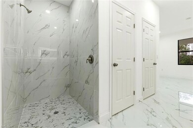 Bathroom with a marble finish shower and marble finish floors