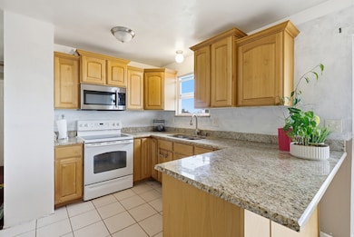 Open kitchen featuring granite countertops and tile floors.