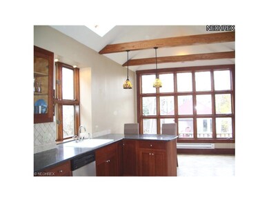 1453 Alameda Kitchen with vaulted ceiling, skylight, wall of windows, access to rear deck, granite countertops, natural stone floors and backsplash and custom cabinets.