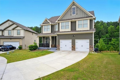 Craftsman-style house featuring board and batten siding, a garage, concrete driveway, a front lawn, and covered porch