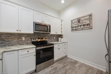 Kitchen with light wood-style floors, white cabine