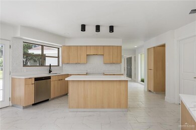 Kitchen featuring tasteful backsplash, sink, a kitchen island, light tile patterned flooring, and dishwasher