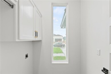 Laundry area with electric dryer hookup and cabinets